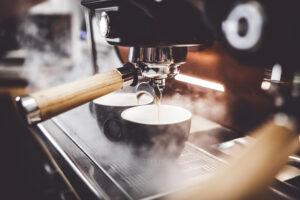 Espresso pouring from coffee machine at cafe